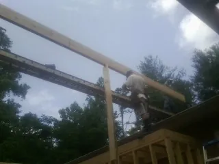 Carpenter setting a ridge beam over a new addition frame — Ice Dam Removal by Roofing Brothers in Pavilion