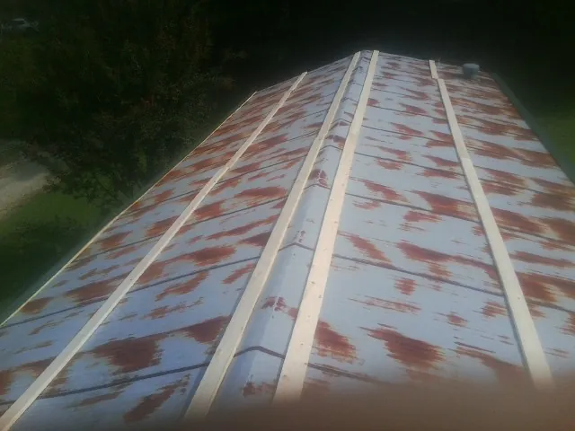 Rusted metal roof panels with new wood purlins before replacement — Storm Damage Roof Repair in Pavilion by Roofing Brothers